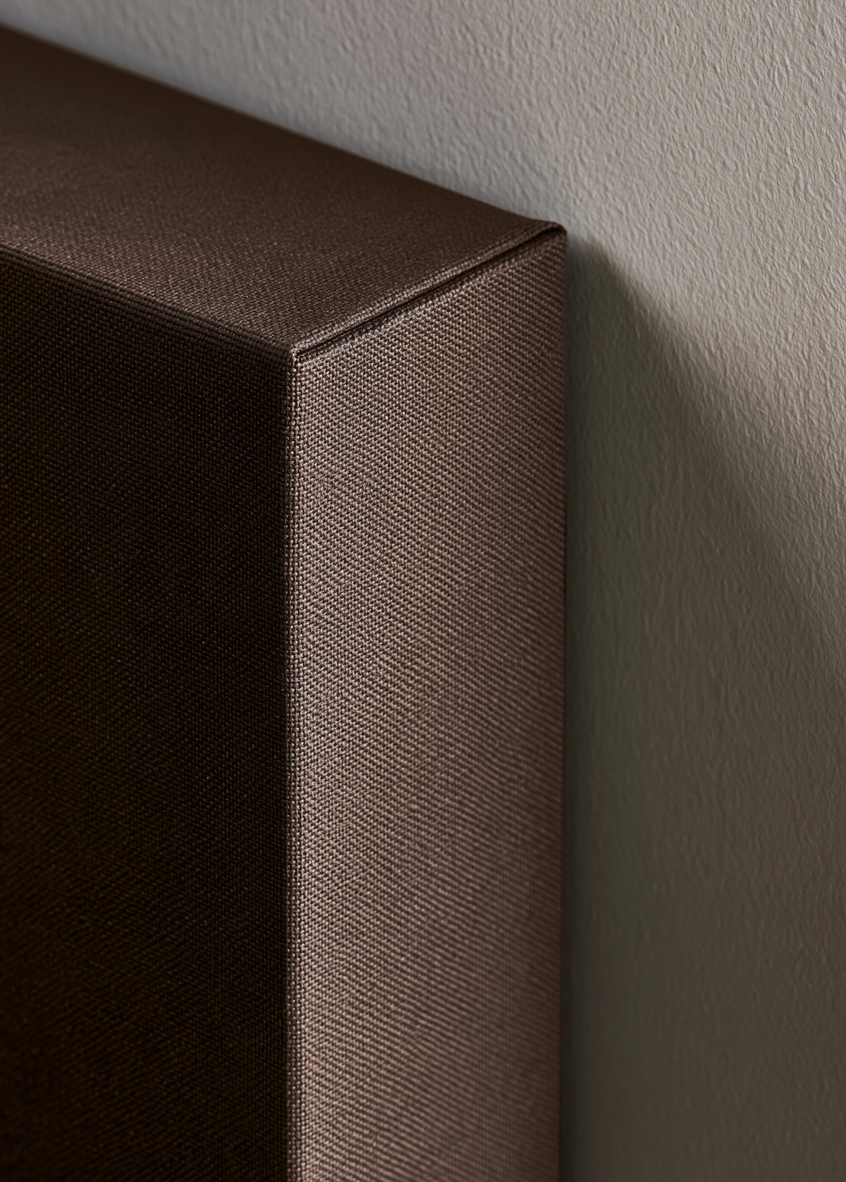 Close-up of the deep wrapped edge of a canvas on a plaster wall